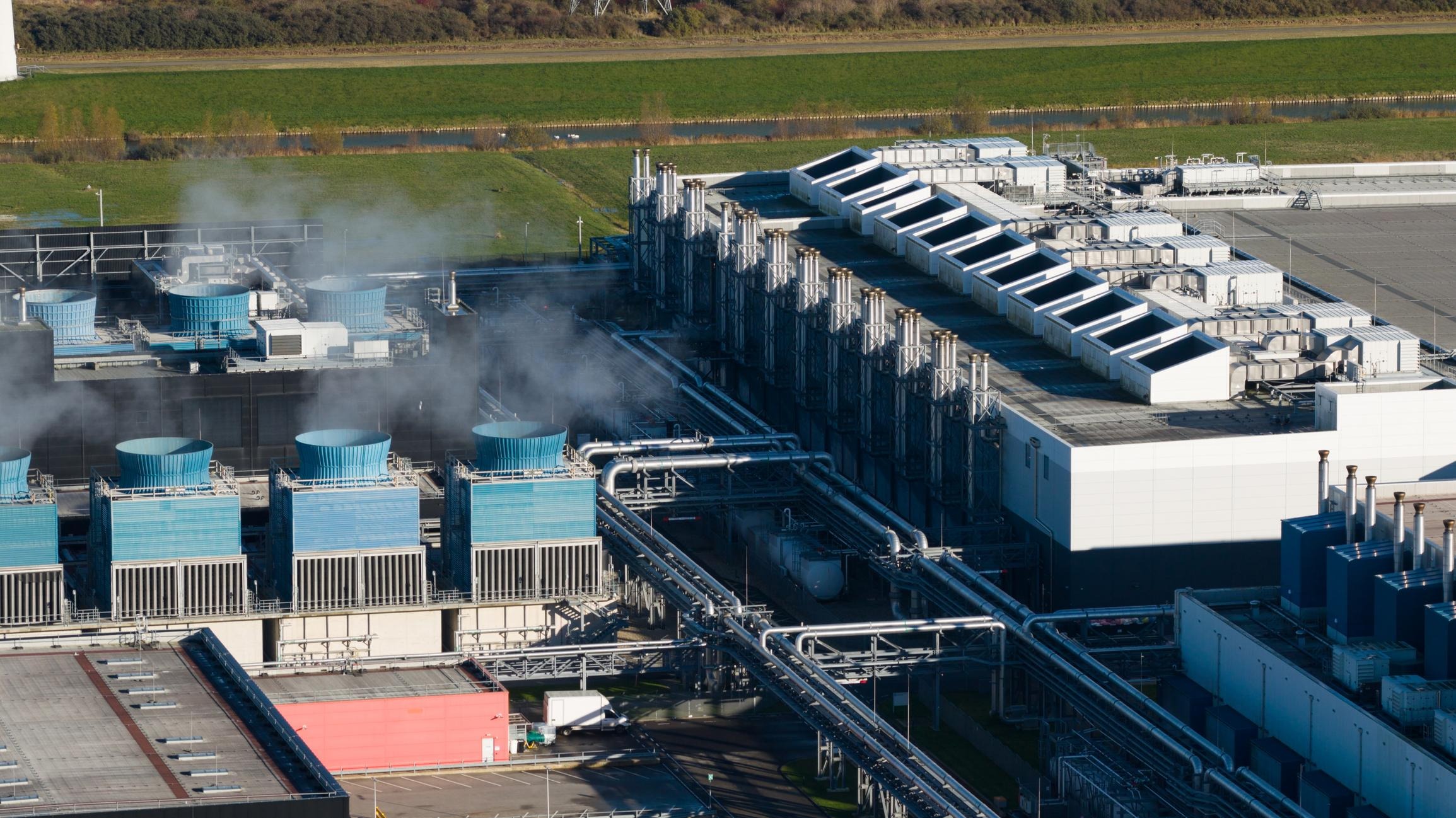 Industrial cooling towers releasing steam at modern factory